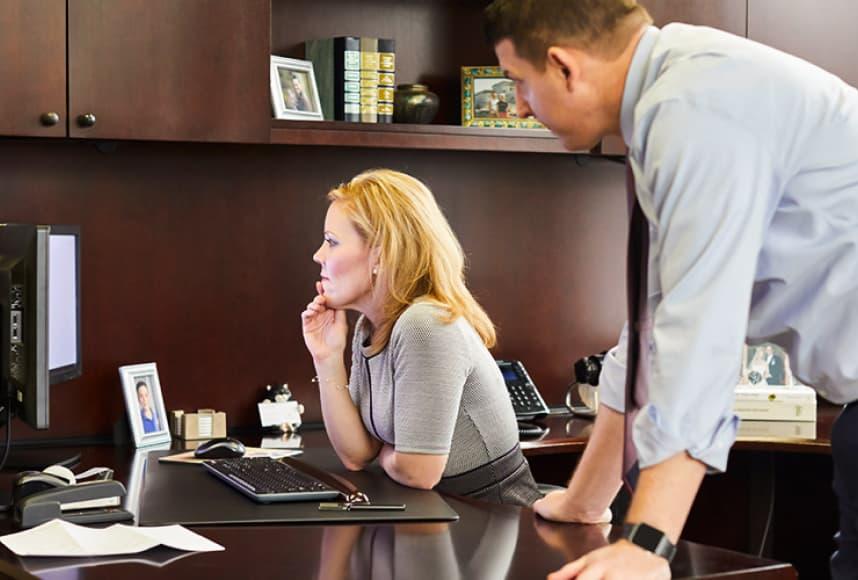 Two CIP staff members looking at a computer screen and discussing investment management