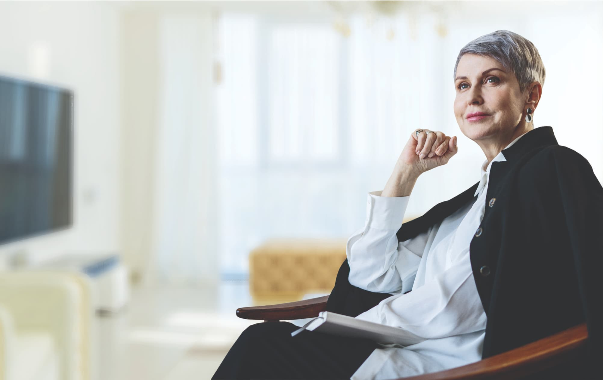 A woman sitting and smiling contentedly in a chair.